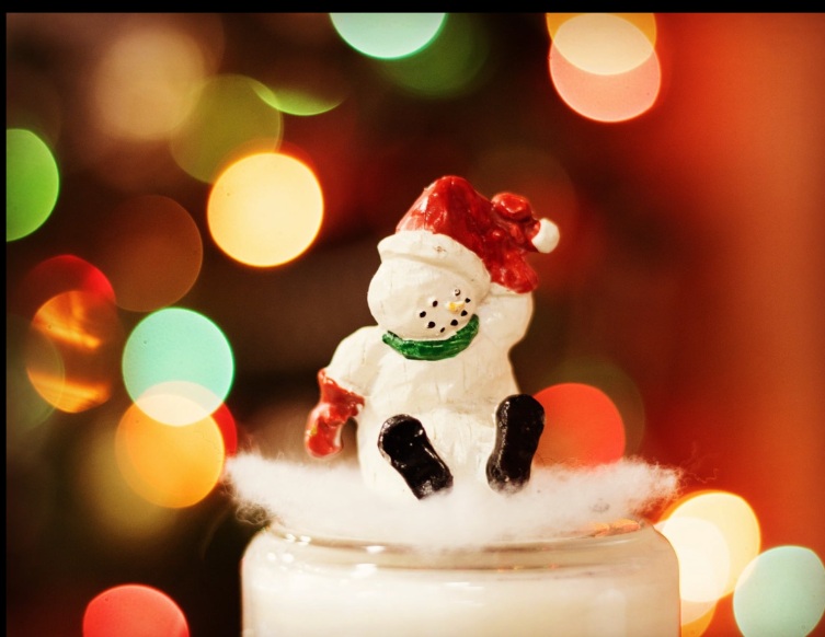 Snowman ornament illuminated by colorful blurred lights
